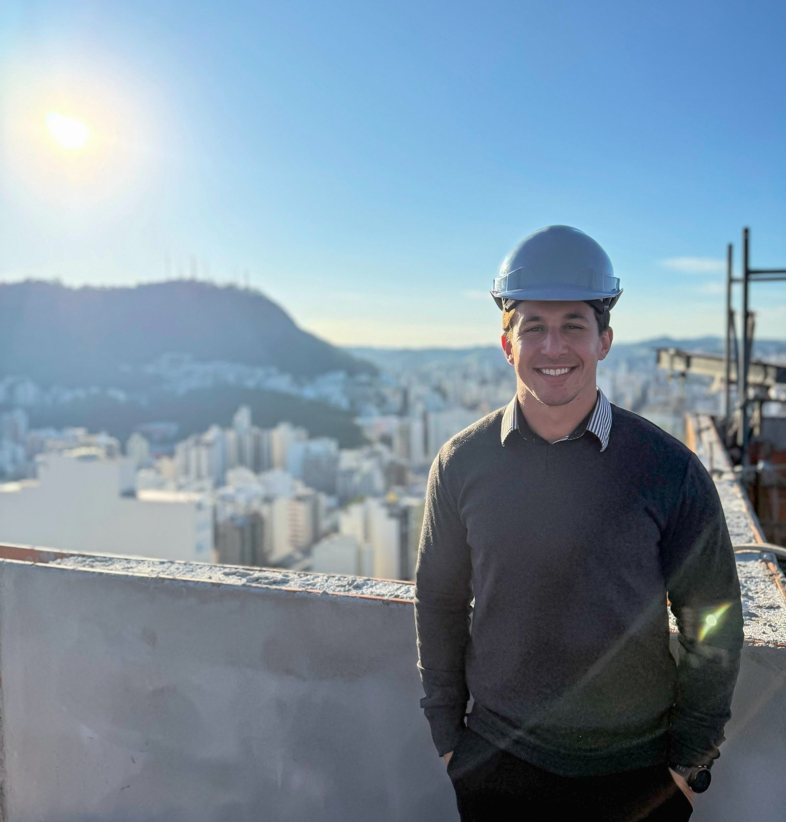 Fábio Coelho em uma obra, com a cidade ao fundo